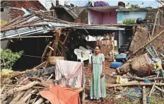  ?? PTI ?? A woman stands near her damaged house, hit by storm ‘Titli’, in Srikakulam yesterday. Some areas received up to 300mm of rainfall within 24 hours, creating flood situations.