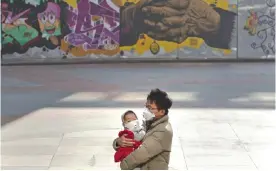  ?? — AP ?? BEIJING: A man and a child wear masks during a heavily polluted day.