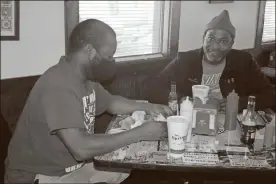  ?? Doug Walker ?? Montavious Thomas (left) and William Montgomery eat lunch at the Shrimp Boat on Wednesday. The restaurant has been sold to local investors Jeremy Duke, Truman Webb and Tyson Dube.