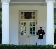  ?? (AP/Evan Vucci) ?? A Marine stands guard Wednesday outside the West Wing of the White House, signifying that President Donald Trump was in the Oval Office.