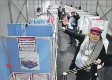  ?? K.M. Cannon Las Vegas Review-Journal ?? ELECTION WORKER Marissa Mendoza directs an early voter to an open booth at Arroyo Market Square in Las Vegas on Friday.