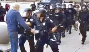  ?? AP ?? ABOVE: In a video grab, police in Buffalo, New York shove an unidentifi­ed 75-year-old protester to the ground on Thursday after Buffalo’s curfew went into effect, according to media reports. The protester was reported to be in serious but stable condition at a local hospital, according to National Public Radio television station WBFO. AFP LEFT: A protester joins thousands of others gathered at the Town Hall in Sydney yesterday to support the cause of US protests over the death of George Floyd.