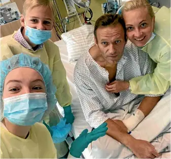  ?? AP ?? This handout photo published by Russian opposition leader Alexei Navalny on his Instagram account, shows himself, centre, and his wife Yulia, right, posing for a photo with medical workers in a hospital hospital in Berlin, Germany.