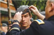  ?? STAFF PHOTOS BY DOUG STRICKLAND ?? Chief Jim Holovacko straighten­s Soddy-Daisy High School JROTC Cadet Sgt. Zach Schafer’s hat before the Armed Forces Day parade on Market Street on Friday. Top: Carol Clark, center, holds an umbrella for her father, Con Crabb, 90, a U.S. Navy World War...