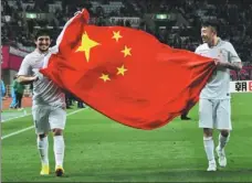  ?? XINHUA ?? Aloisio holds the Chinese national flag with Shandong Luneng teammate Wang Yongpo after an AFC Champions League match against Japan’s Cerezo Osaka in 2014.