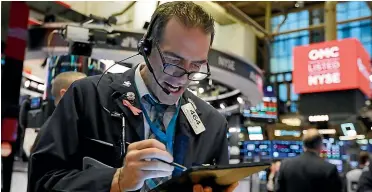  ?? AP ?? Trader Gregory Rowe works on the floor of the New York Stock Exchange yesterday. Stocks are opening sharply lower on Wall Street, pushing the Dow Jones Industrial Average down more than 700 points, as virus cases spread beyond China, threatenin­g to disrupt the global economy.