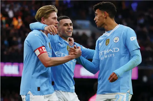  ?? Reuters ?? Manchester City’s Kevin De Bruyne, Phil Foden and Matheus Nunes celebrate the fifth goal against Huddersfie­ld Town in the FA Cup at the Etihad Stadium