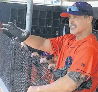  ?? AP PHOTO ?? Cleburne Railroader­s’ Rafael Palmeiro watches play from the dugout before heading back on the field during a spring training baseball game in Cleburne, Texas, on Thursday.