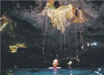  ?? ?? A tourist swims in a water-filled sinkhole known as cenote at Aktun Chen natural park, near the constructi­on site of Section 5 South of the Mayan Train between the resorts of Playa del Carmen and Tulum.