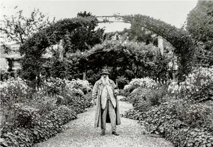  ?? GEORGE RINHART CORBIS VIA GETTY IMAGES ?? Claude Monet stands in his garden in Giverny, France. He also spent time in London, where he created many of his iconic works. Scientific analysis and letters to his wife suggest that his London works were inspired by the industrial air pollution prevalent at the time.