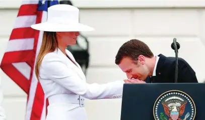  ?? REUTERS ?? Melania Trump, junto a Macron en 2018, vistiendo el sombrero que ahora sale a subasta