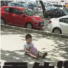  ??  ?? ↓男童坐在停車格上替母­親霸車位。（辜小姐提供）