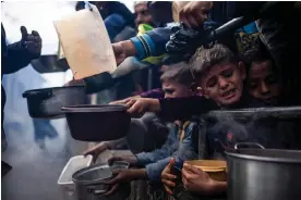  ?? Photograph: Fatima Shbair/AP ?? Palestinia­ns line up for a free meal in Rafah, Gaza Strip, on 16 February.