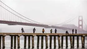  ?? Stephen Lam / The Chronicle ?? People fish at Torpedo Wharf near the Golden Gate Bridge in April. Engineers devised a plan to reduce the bridge’s noisiness caused by vibrating safety slats.