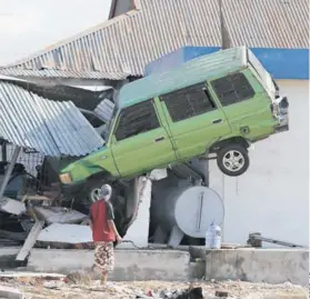  ??  ?? La violencia del tsunami arrasó con todo a su paso y lanzó vehículos contra las casas.