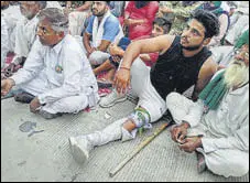  ??  ?? A protester hurt during lathicharg­e by police in Hisar; an injured cop lying on a stretcher at a hospital after the clash on Sunday.