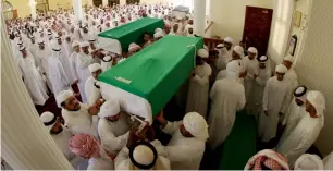  ?? —Photos by M. Sajjad ?? Family members carry the coffins for funeral prayers at Al Shahaba Mosque and (below) they console each other at the Sharjah graveyard after the bodies are buried on Sunday.