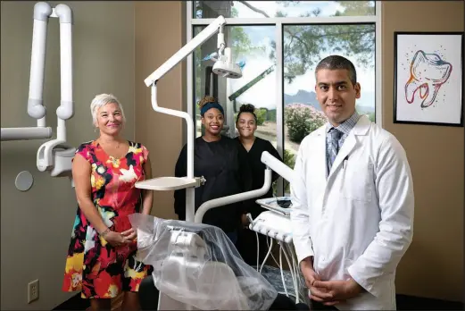  ?? STEVE MARCUS ?? Dr. Pouyan Shahrokh poses with Genie Cinquegran­i, office manager, and dental assistants Ame Clark, left, and Krista Nuno at Rampart Dental Atelier. In an effort to make his customers feel safe, Shahrokh said his entire staff is vaccinated against COVID-19.