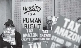  ?? AP FILE PHOTO BY ELAINE THOMPSON ?? Members of the public look on at a Seattle City Council on May 14 before the council voted to approve a tax on large businesses such as Amazon and Starbucks to fight homelessne­ss in Seattle.