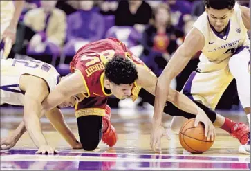  ?? Elaine Thompson Associated Press ?? BENNIE BOATWRIGHT, center, of USC scrambles for the ball with Andrew Andrews, left, and Matisse Thybulle of Washington in the second half. The Trojans had a winning streak ended at seven games.