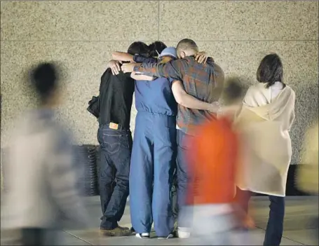  ?? Photograph­s by Patrick T. Fallon For The Times ?? PEOPLE hug at a vigil at Samuelson Chapel at California Lutheran University for the victims of the massacre at Borderline Bar and Grill.