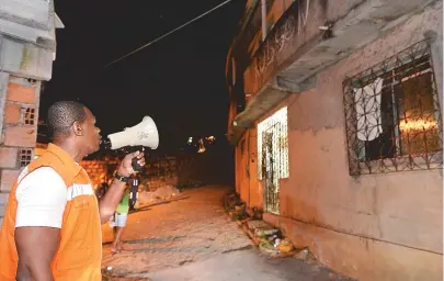  ??  ?? Servidor da prefeitura usa megafones para alertar os moradores do Calabetão durante treinament­o