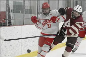  ?? PHOTO BY JIM MICHAUD — BOSTON HERALD ?? Arlington’s Quinlan McNulty (12) and by Hingham’s Mason Lemieux (23) after a flying puck near the Hingham goal in the first period Sunday, February 12, 2023, in Watertown, Mass.