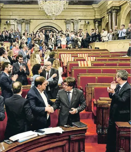  ?? ÀLEX GARCIA ?? Junqueras y Puigdemont se saludan tras la votación de la ley y ante la ausencia de parte de la oposición