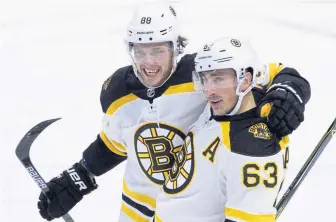  ?? AP PHOTO ?? NOT TRIPPED UP: David Pastrnak celebrates a goal with teammate Brad Marchand during the Bruins’ 4-1 victory against the Senators last night in Ottawa.