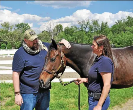  ?? PHOTOS PROVIDED ?? Retired U.S. Marine Corps Sgt. Matt Ryba, left, admires a horse used in Columbia University’s Man O’ War Project at the Bergen Equestrian Center in New Jersey. Ryba is not a participan­t in the program, but works with veterans through the university.