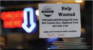  ?? NAM Y. HUH – THE ASSOCIATED PRESS ?? A hiring sign is displayed at a restaurant in Highland Park, Ill., on July 14. The number of Americans applying for unemployme­nt benefits last week rose to its highest level in more than eight months.