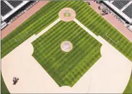  ?? Elaine Thompson / Associated Press ?? Grounds crew members continue to keep the Mariners’ field in playing shape Monday.