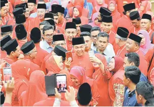  ?? — Gambar Bernama ?? RAMAH MESRA: Ahmad Zahid (tengah) melayan para perwakilan yang ingin bergambar dengannya selepas merasmikan Persidanga­n Perwakilan UMNO Bahagian Kuala Terengganu dekat Kuala Nerus, semalam.