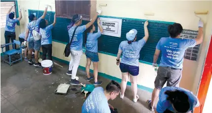  ?? PHOTO BY RUSSELL PALMA ?? HELPING HANDS Volunteers paint a classroom at the Rosauro Almario Elementary School in Tondo, Manila ahead of the official launch on May 15 of the Education department’s Brigada Eskwela.