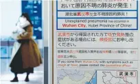  ?? REUTERS ?? A WOMAN wearing a mask walks past a quarantine notice about the outbreak of coronaviru­s in Wuhan, China at an arrival hall of Haneda airport in Tokyo, Japan, Jan. 20.