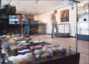  ?? Natalie Williams / Associated Press ?? Customers peruse products at Firestorm in Bangor, Maine, on Friday, the first day of legal recreation­al marijuana sales in the state.