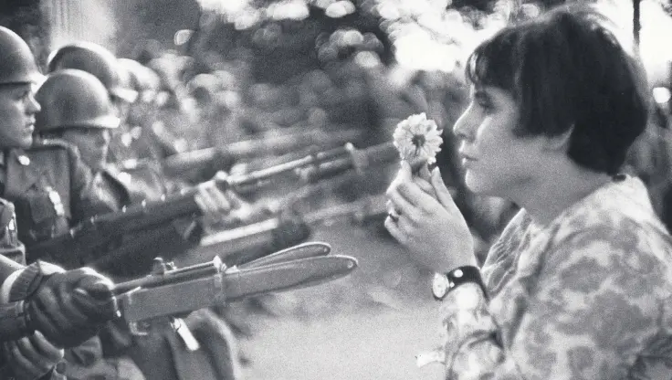  ??  ?? Jane Rose Kasmir holds a flower up to soldiers during an anti-Vietnam war demonstrat­ion outside the Pentagon, Oct. 21, 1967.