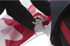  ?? CHRIS YOUNG/THE CANADIAN PRESS ?? Members of the Toronto Police Service ceremonial unit hold the Canadian flag as they prepare to raise it during the welcome ceremony.