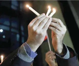  ?? — Reuters ?? An Egyptian man holds candles in the memory of victims of the attack in north Sinai in front of the Press Syndicate in Cairo, on Wednesday.