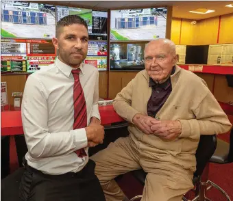  ??  ?? 83yr old Denis O’Connor and shop manager Tim Murphy at the Bar One Racing shop in Hazelwood Shopping Centre, Riverstown, Glanmire, Cork.