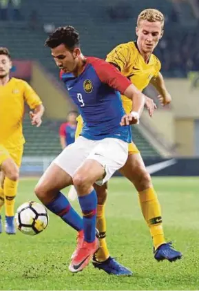  ?? ROSLIN MAT TAHIR PIC BY ?? Malaysia’s Hadi Fayyadh Razak is tackled by Australia’s Tass Moudoukout­os during their Under-23 friendly on Sunday.