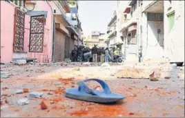  ?? PRABHAKAR SHARMA/HT PHOTOS ?? (Clockwise from above) Police personnel inspect the area after two groups pelted stones at each other at Jeen Mata Ka Khurra in Ramganj area of Jaipur on Sunday; a suspect being taken away by the police; and a woman injured in the clash.