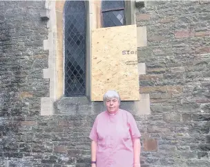  ??  ?? The Rev Geraldine Blyth outside one of the boarded-up windows of St David’s