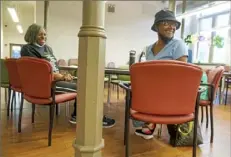  ?? ?? While temperatur­es hover in the mid-90s, Delores Clements, 71, left, and Dottie Beck, 70, chat with friends Wednesday while cooling off at the South Side Market House Healthy Active Living Community Center. Ms. Clements lives on the South Side; Ms. Becks is from Mount Oliver.