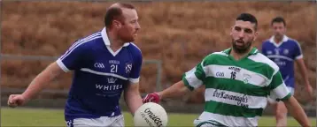  ??  ?? Fergus Heffernan of Oylegate-Glenbrien about to deliver a pass as James Carty (Shamrocks) moves in.