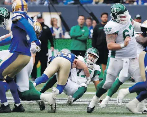  ?? JOHN WOODS/THE CANADIAN PRESS. ?? Roughrider­s QB Zach Collaros gets hit by Winnipeg’s Jeff Hecht during the fourth quarter on Saturday at Investors Group Field. Collaros was forced to leave the game and undergo concussion protocol. This year’s Riders have five TD passes from Collaros.