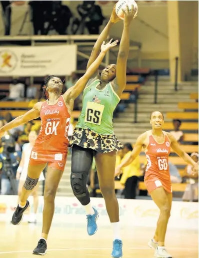  ??  ?? England goalkeeper Ama Agbeze (left) tries her best to intercept a pass to Jamaica’s Jhaniele Fowler (centre) while goal defence Layla Guscoth looks on during the teams’ third and final LASCO Sunshine Series game at the National Indoor Sports Centre on October 15, 2018.