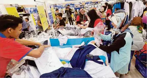  ??  ?? KAKITANGAN Tesco membantu murid mencari kelengkapa­n sekolah di Pasaraya Tesco, Cheng pada Program Titipan Kasih Kembali Ke Sekolah.