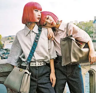  ??  ?? Su melena fucsia de flequillo recto permite que sea fácil no perderlas la pista. Las gemelas modelos Ami y Aya Suzuki.