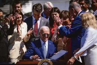  ?? Pete Marovich / New York Times ?? President Biden signs the CHIPS and Science Act of 2022, in a ceremony on the South Lawn of the White House. The bill is designed to boost U.S. semiconduc­tor production and research.